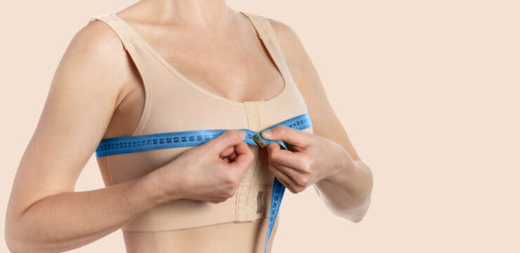 Young woman taking measurements after breast augmentation. Copy space.